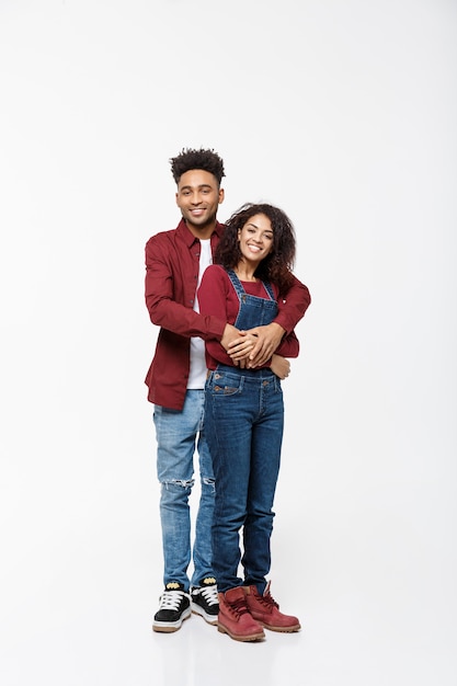 Ritratto di corpo pieno di giovani afroamericani abbracciare le coppie, con un sorriso sulla datazione.