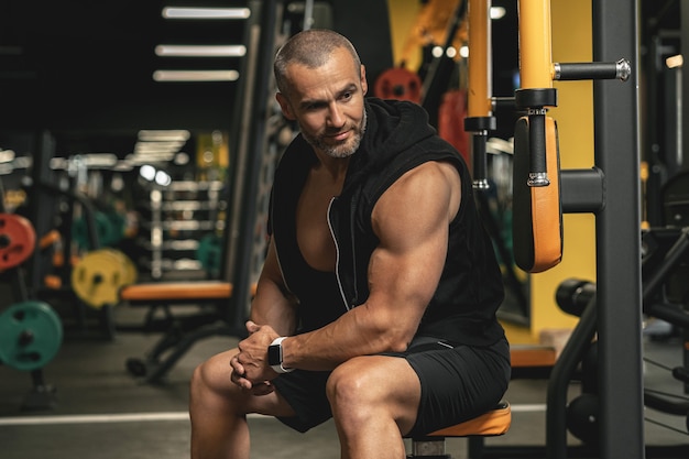 Ritratto di culturista bello e muscoloso in una palestra durante l'allenamento