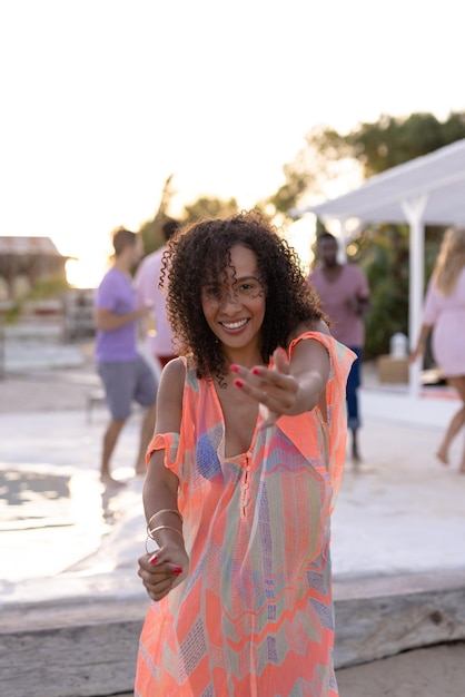 Ritratto di donna afroamericana felice che balla e sorride in spiaggia, con spazio per la copia. Trascorrere tempo di qualità, stile di vita, estate e concetto di vacanza.