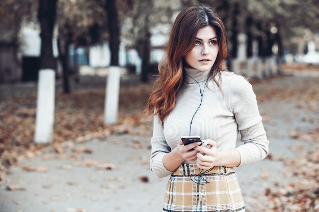 Ritratto di donna alla moda tenendo il telefono cellulare