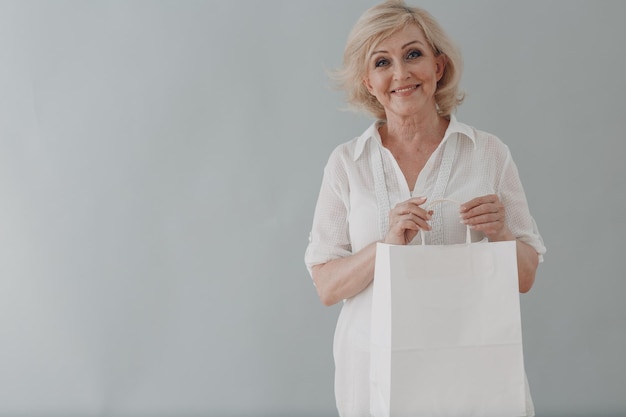 Ritratto di donna anziana caucasica anziana dai capelli grigi ritratto con borse della spesa