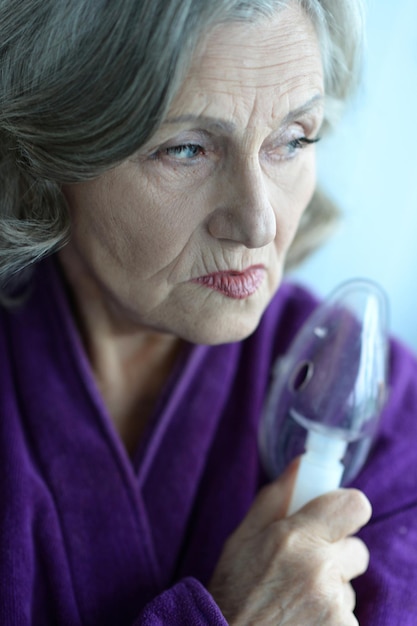 Ritratto di donna anziana con inalazione di influenza