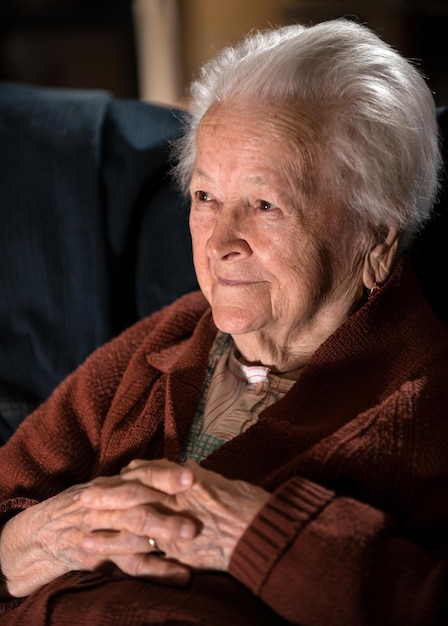 Ritratto di donna anziana dai capelli grigi sorridente in posa a casa