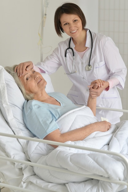 Ritratto di donna anziana in ospedale con medico premuroso