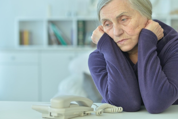 Ritratto di donna anziana sconvolta con il telefono