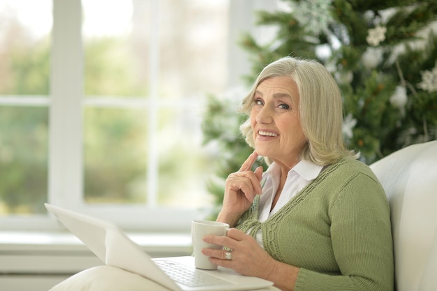 Ritratto di donna anziana sorridente che utilizza laptop