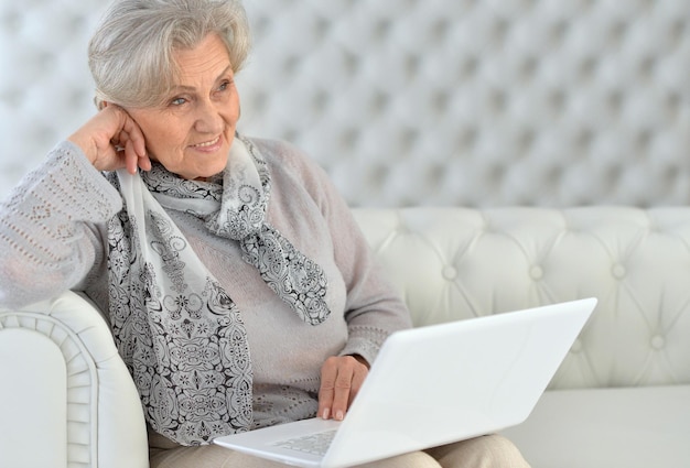 Ritratto di donna anziana sorridente con laptop