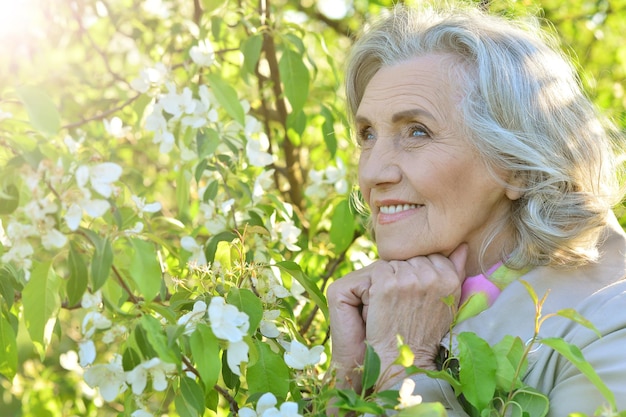 Ritratto di donna anziana sorridente in posa nel parco estivo