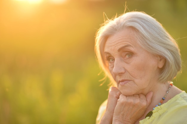 Ritratto di donna anziana sorridente nel parco in estate