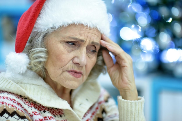 Ritratto di donna anziana triste in cappello di Babbo Natale