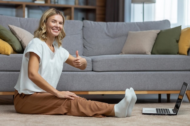 Ritratto di donna attiva a casa facendo fitness ed esercizio fisico e casalinga matura yoga guardando