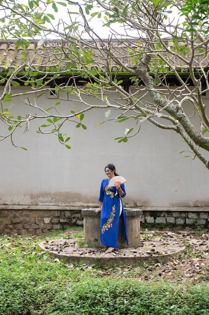 Ritratto di donna caucasica in abito Ao Dai all'aperto