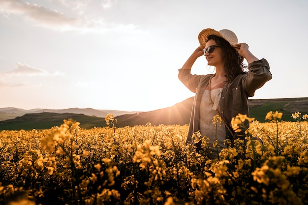 Ritratto di donna che cammina tra i fiori in campagna. Concetto di malinconia