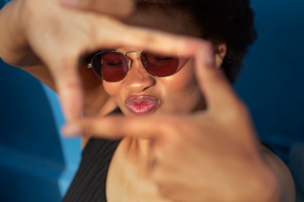 Ritratto di donna che fa una cornice della fotocamera con le mani