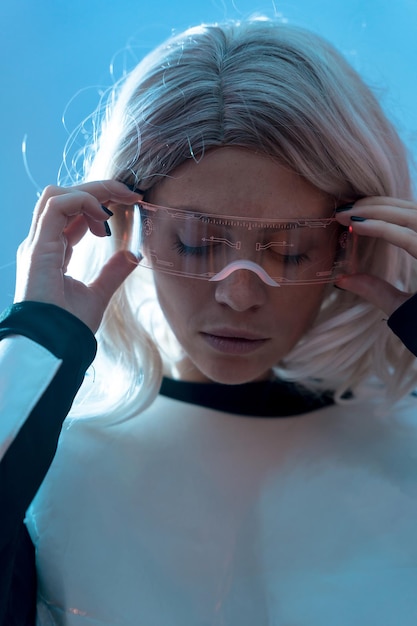 Ritratto di donna con gli occhiali futuristici sfondo blu futuro e concetto di realtà virtuale