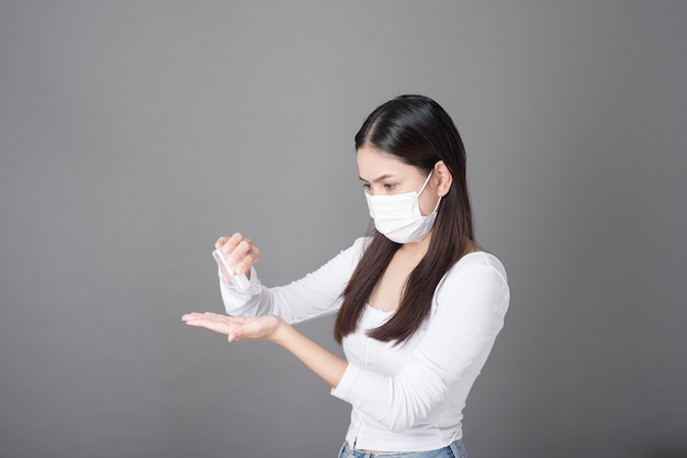 Ritratto di donna con maschera chirurgica con disinfettante in gel alcolico