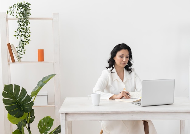 Ritratto di donna d'affari in abito bianco che lavora nel computer portatile dell'ufficio Proprietario di piccola impresa persone dipendente freelance marketing online sme e-commerce concetto di telemarketing