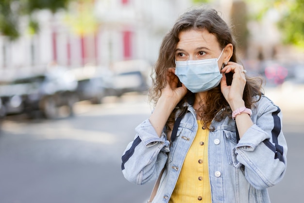 Ritratto di donna dai capelli ricci in maschera medica in città