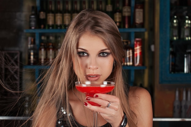 Ritratto di donna di bellezza con cocktail in un bar