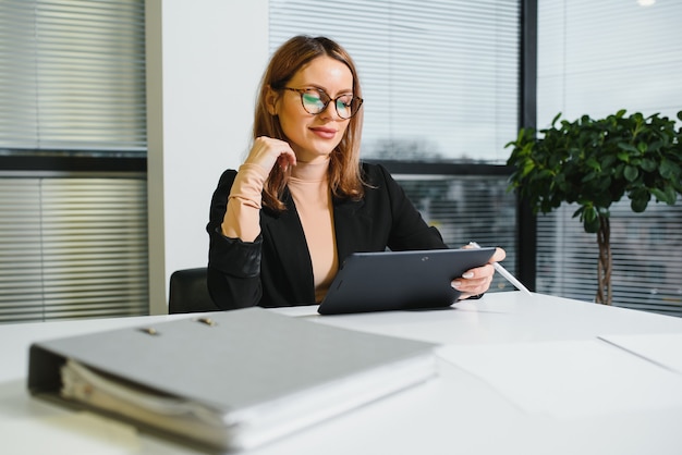 Ritratto di donna di successo seduto in ufficio