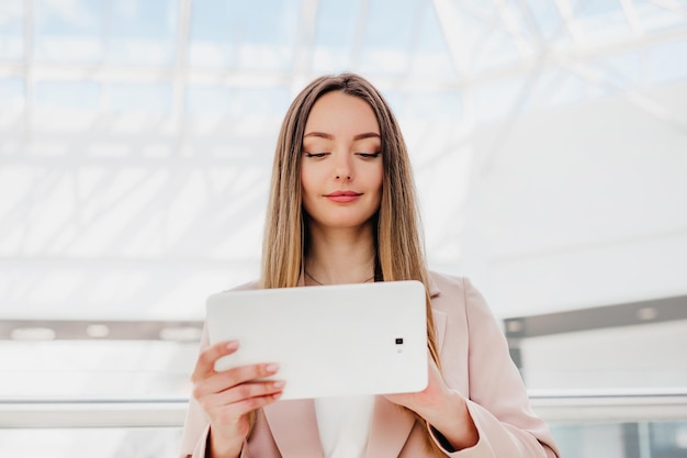 Ritratto di donna di successo utilizzando la tavoletta digitale nell'edificio per uffici