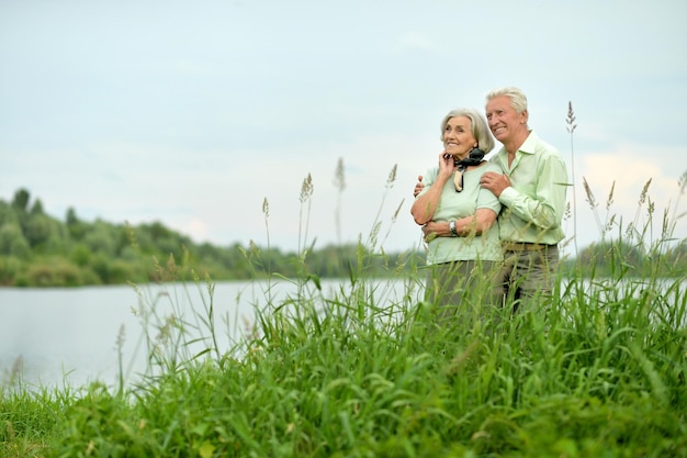 Ritratto di donna e uomo senior felici dal lago