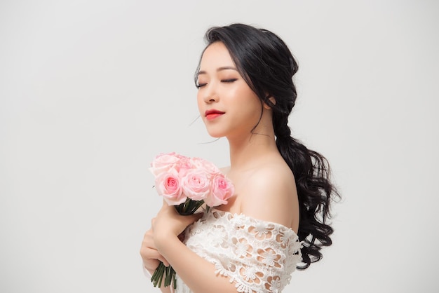 Ritratto di donna elegante con bouquet di fiori su sfondo bianco