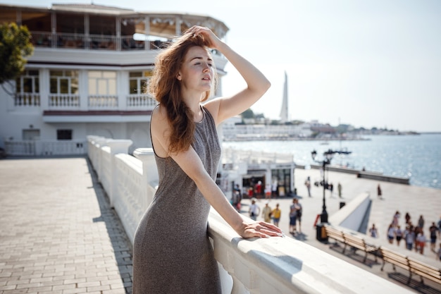 Ritratto di donna elegante splendida giovane redhair che indossa cappotto lungo alla moda sulla strada della città