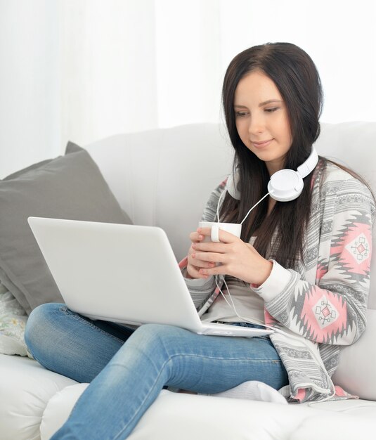 ritratto di donna felice che utilizza laptop con tè