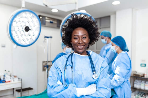 Ritratto di donna felice chirurgo in piedi in sala operatoria