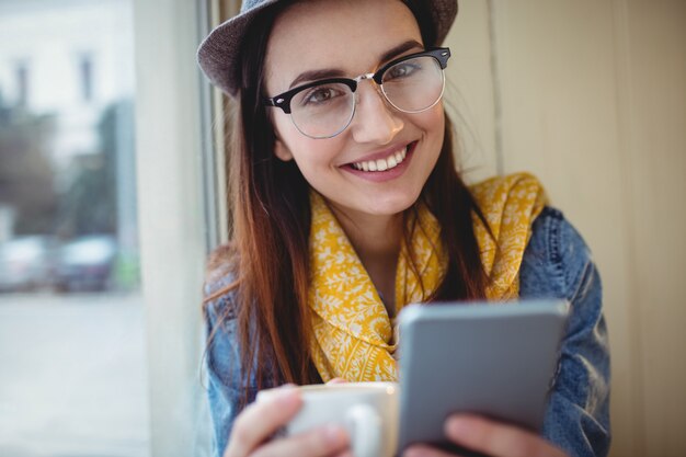 Ritratto di donna felice con il cellulare al caffè