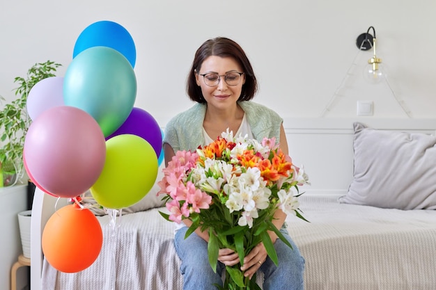 Ritratto di donna felice di mezza età con bouquet di palloncini di fiori