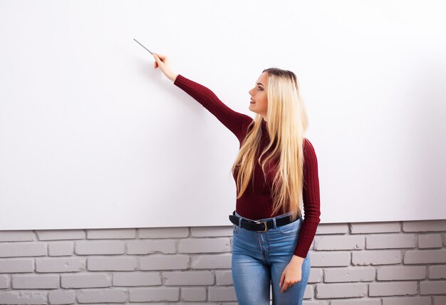 Ritratto di donna felice giovane imprenditrice vicino al muro bianco