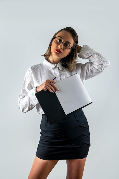 Ritratto di donna in abbigliamento formale azienda appunti e sorridere alla telecamera sfondo isolato