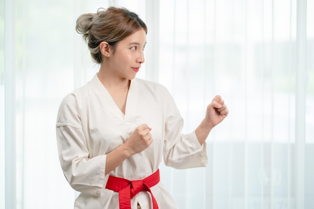 Ritratto di donna in abiti Taekwondo su sfondo bianco.