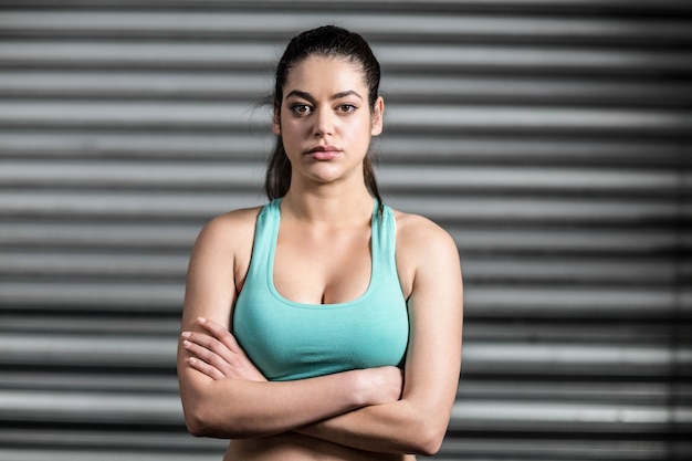 Ritratto di donna in forma con le braccia incrociate in palestra