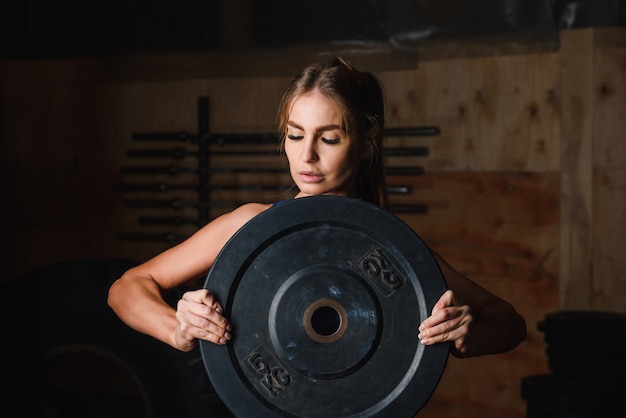 Ritratto di donna in palestra con piastra da 5 kg