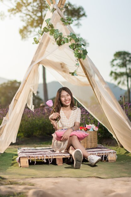 Ritratto di donna in posa in una tenda in un campo di fiori