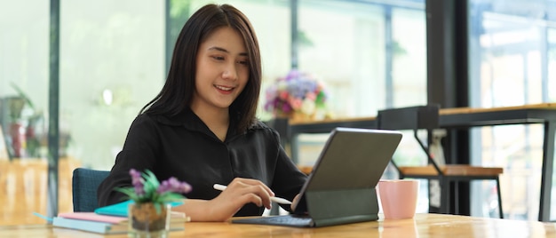 Ritratto di donna libero professionista che lavora con tavoletta digitale sul tavolo da lavoro