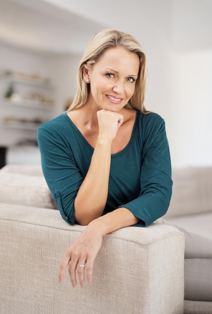 Ritratto di donna matura e pace in casa confortevole e soddisfazione nel fine settimana per riposare Sorriso di persona femminile e atteggiamento sicuro al mattino rilassarsi e orgoglioso nel soggiorno per il benessere