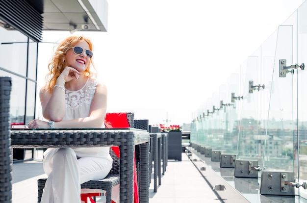 Ritratto di donna matura sorridente godendo di una bella giornata di sole in un caffè fuori. Copia spazio