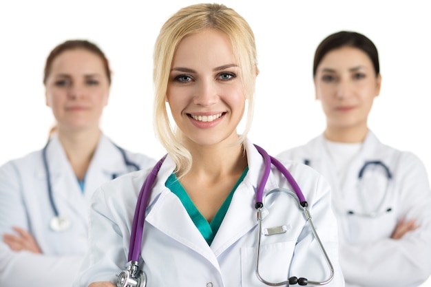 Ritratto di donna medico circondato da equipe medica, guardando e sorridente. Concetto di sanità e medicina.