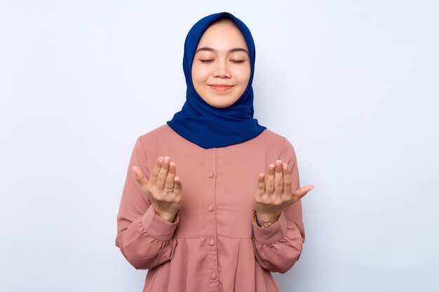 Ritratto di donna musulmana asiatica che prega a braccio aperto isolato su sfondo bianco Concetto di stile di vita religioso della gente