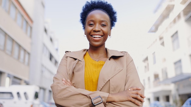 Ritratto di donna nera e braccia incrociate in città per una missione aziendale o una mentalità con fiducia in strada Imprenditore dipendente e persona africana con un sorriso per il successo motivazione o soddisfazione