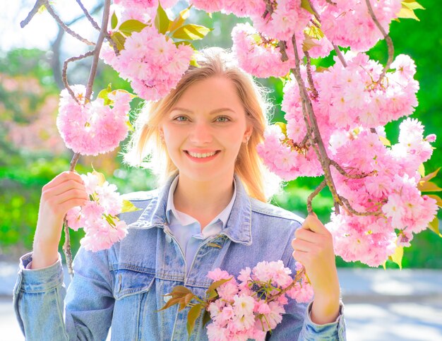 Ritratto di donna romantica di primavera donna in una giornata di sole donna di primavera in fiore di ciliegio ragazza con sakura