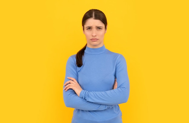 Ritratto di donna sconvolto mani incrociate su sfondo giallo emozioni negative