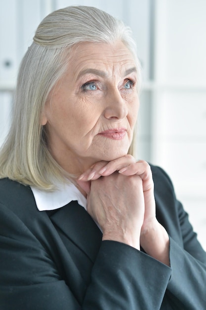 Ritratto di donna senior in abbigliamento formale sorridente alla telecamera