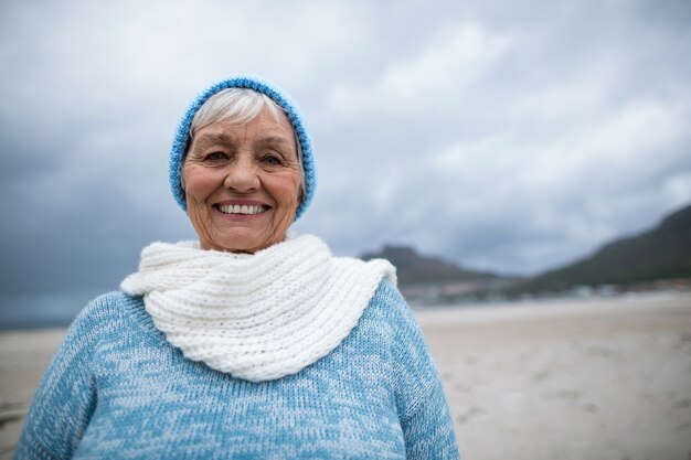 Ritratto di donna senior in piedi sulla spiaggia
