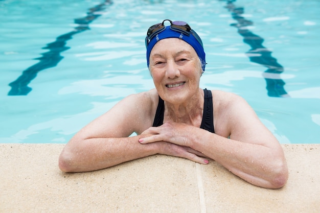 Ritratto di donna senior sorridente in piedi in piscina