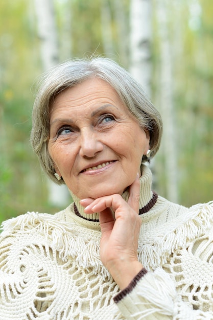 Ritratto di donna senior sulla natura su sfondo autunnale